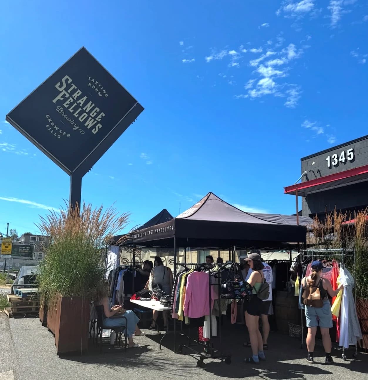 Vintage clothing racks under market tents outside a local brewery