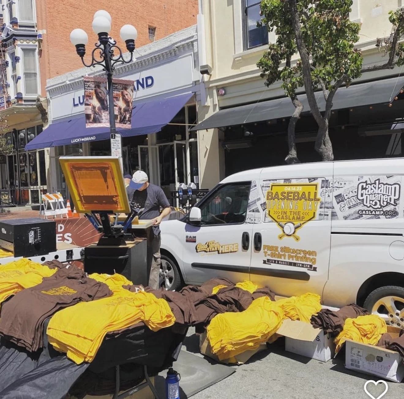 Live silkscreen t-shirt printing pop-up beside a branded van downtown