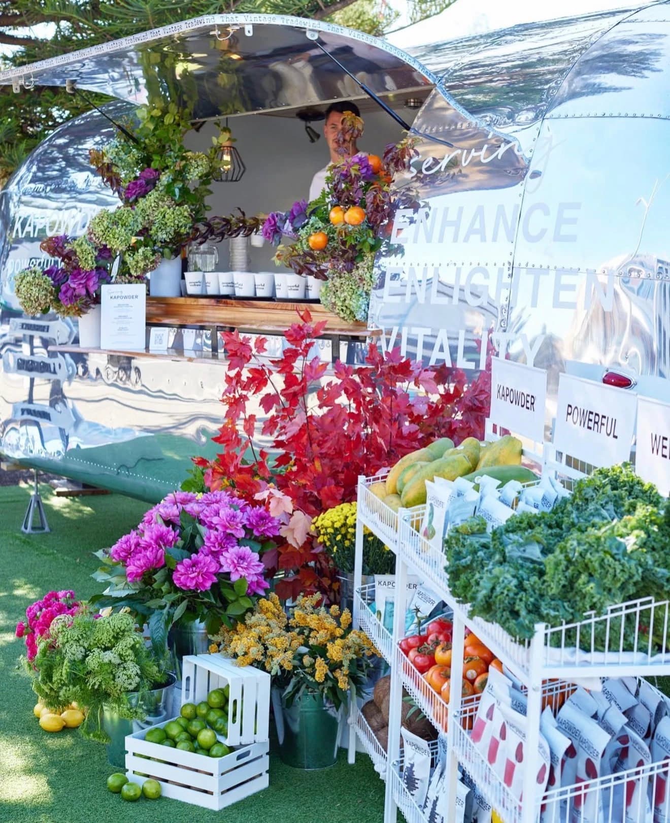 Gleaming Airstream trailer bar decorated with fresh flowers and produce